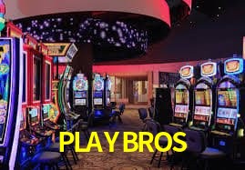 Escena dinámica inspirada en casino con iluminación PLAYBROS, cartas, fichas e íconos de juegos digitales en un espacio moderno de juegos.